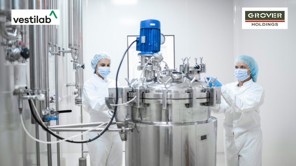 Pharmaceutical factory workers in protective clothing operate production line in sterile working conditions
